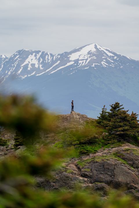 Man standing on a run overlooking the mountains of the Kenai peninsula