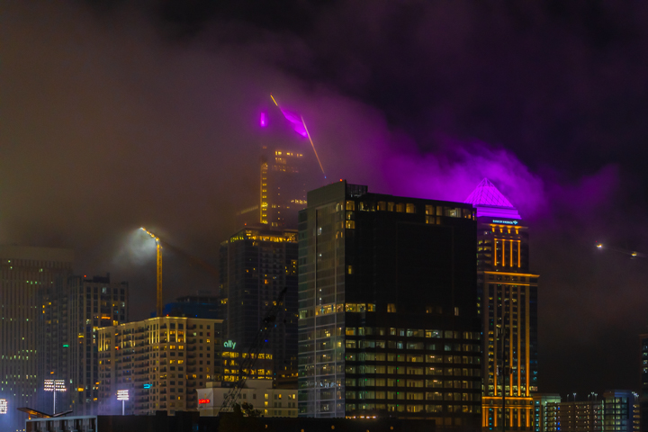 Inversion dragging off of Charlotte skyscrapers lit up purple at night