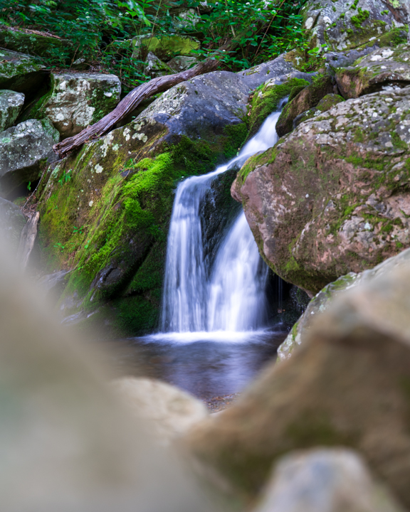 A small double waterfall behind rocks