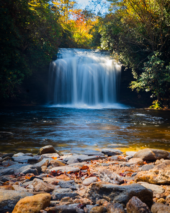 A wide waterfall in front of its lake water